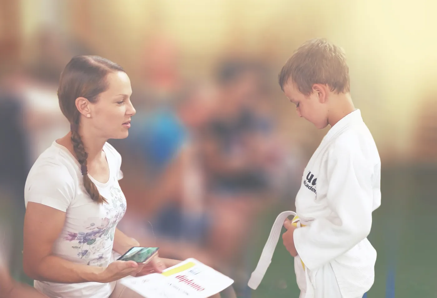 Mama in mladi judoist z diplomo po polaganju pasov